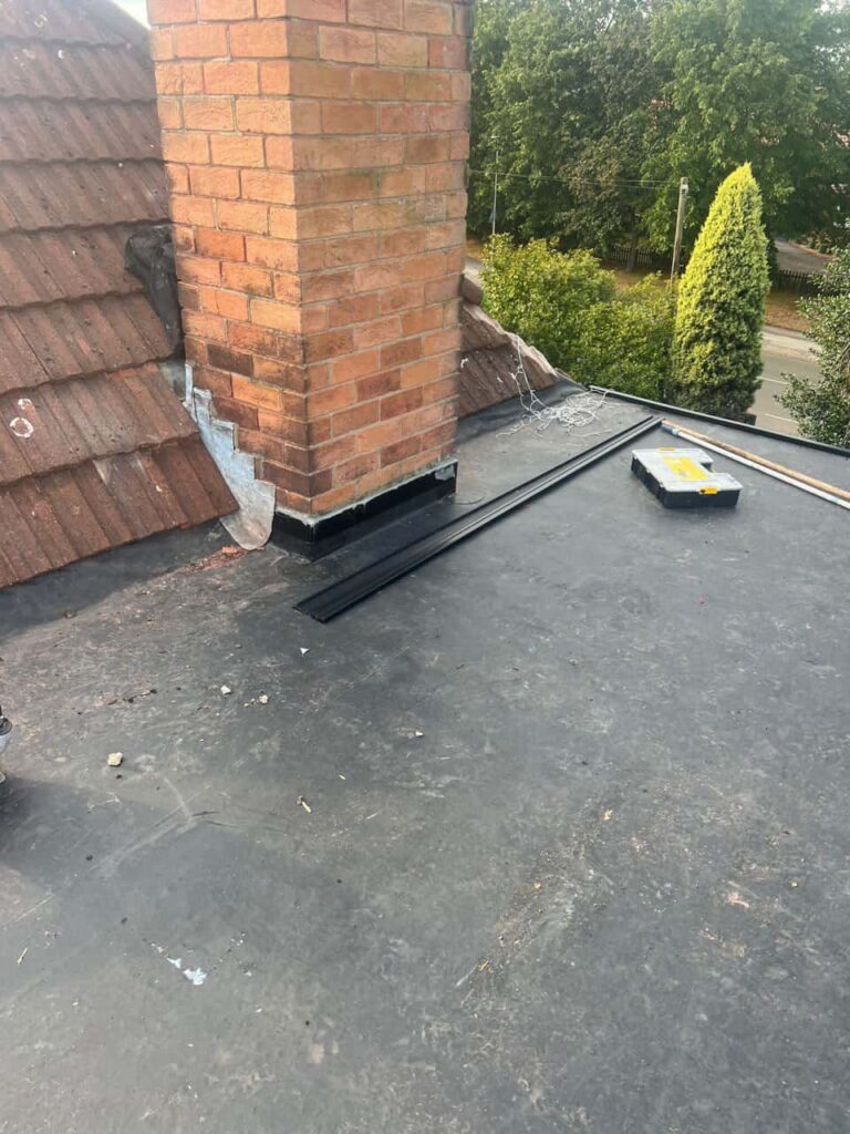 This is a photo of a flat roof which has just been repaired, there is also a chimney stack and some leadwork has also been dressed. Works carried out by Soham Roofing Repairs
